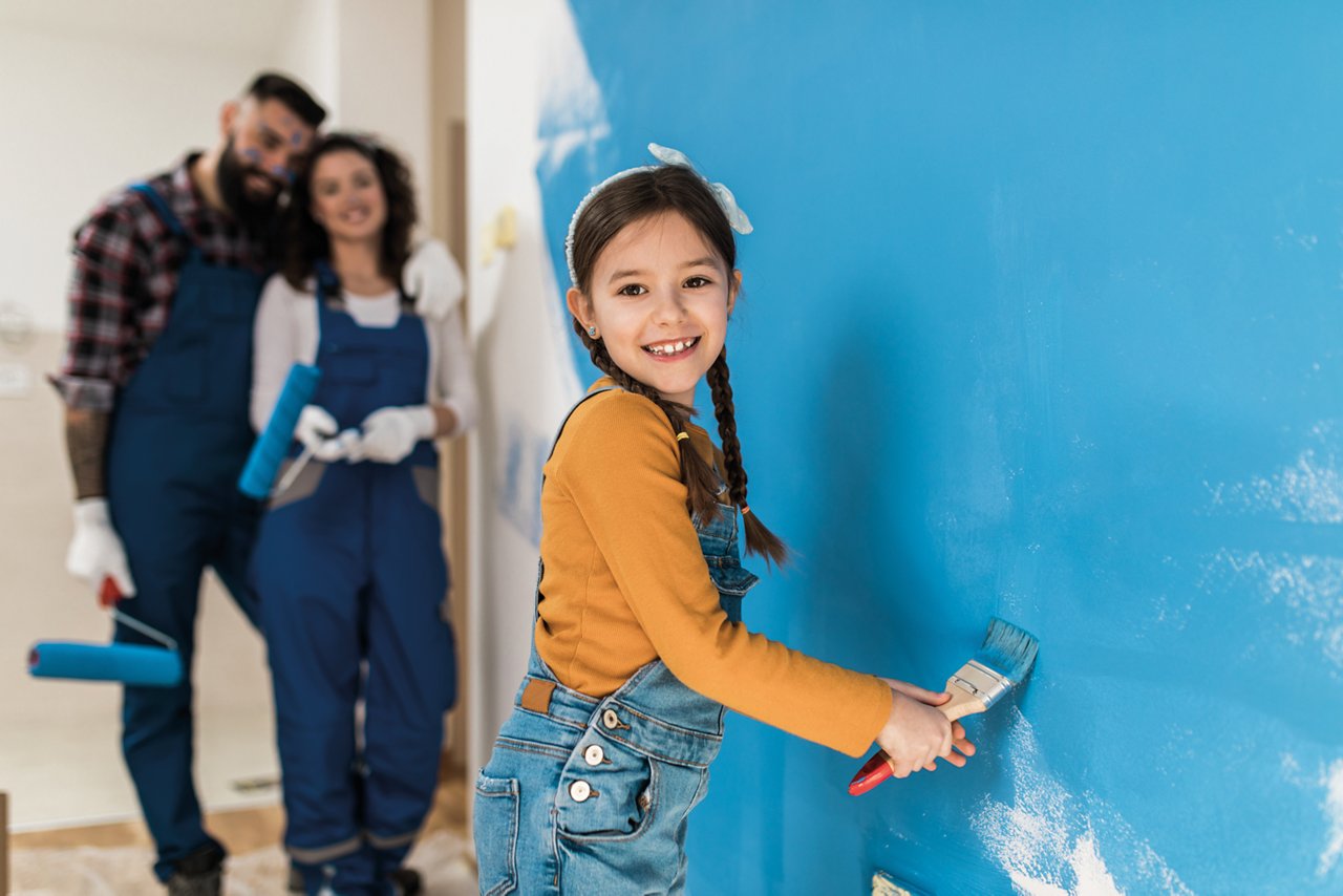 Happy family painting a wall blue together