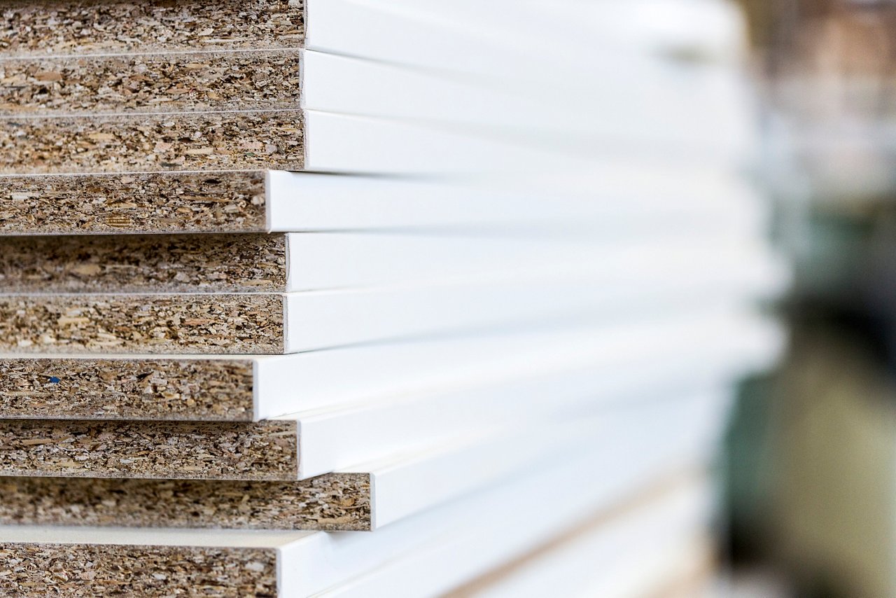 Several stacked white particle boards