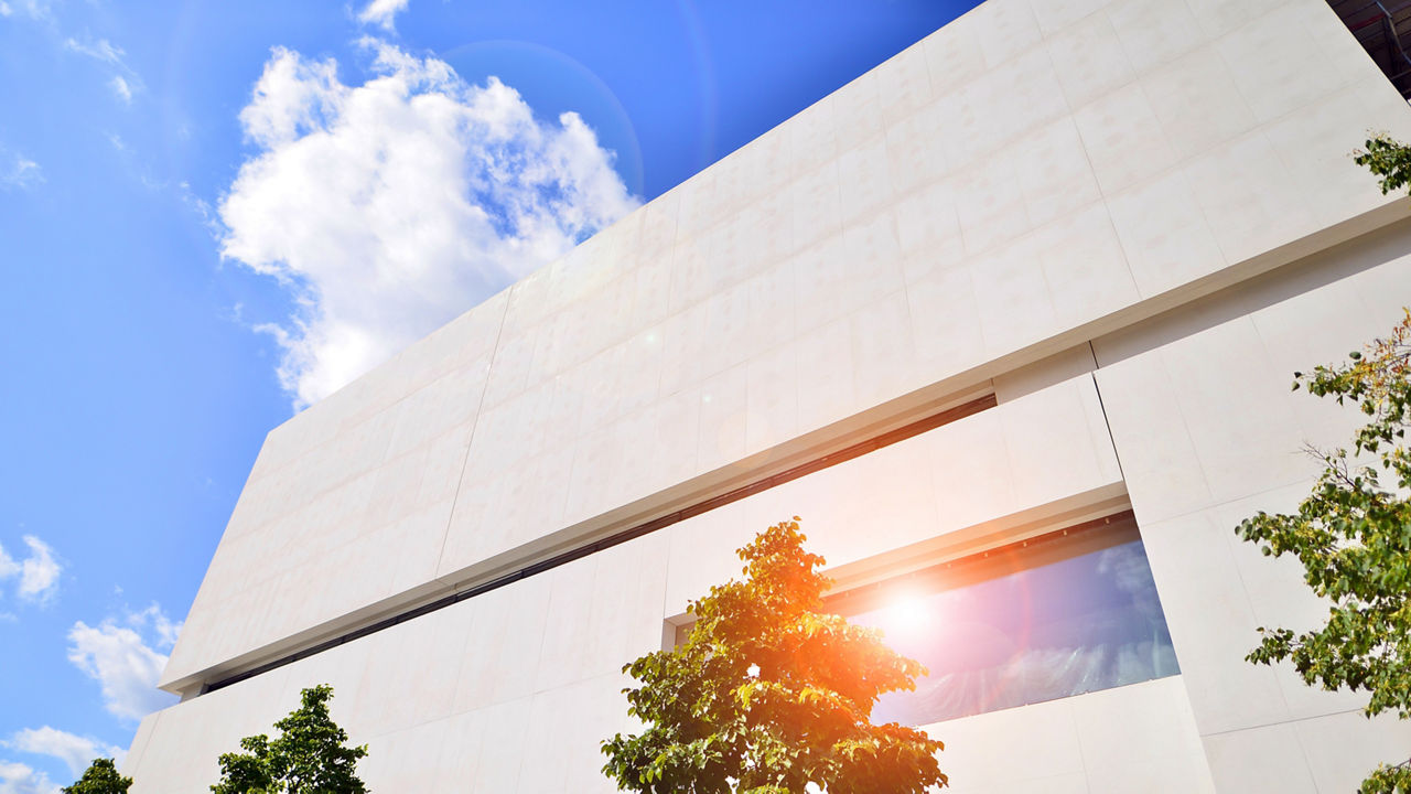 Modern white concrete building walls against blue sky. Eco architecture. Green trees and concrete office building. The harmony of nature and modernity.; Shutterstock ID 2346636329; purchase_order: CON; job: ; client: ; other: 