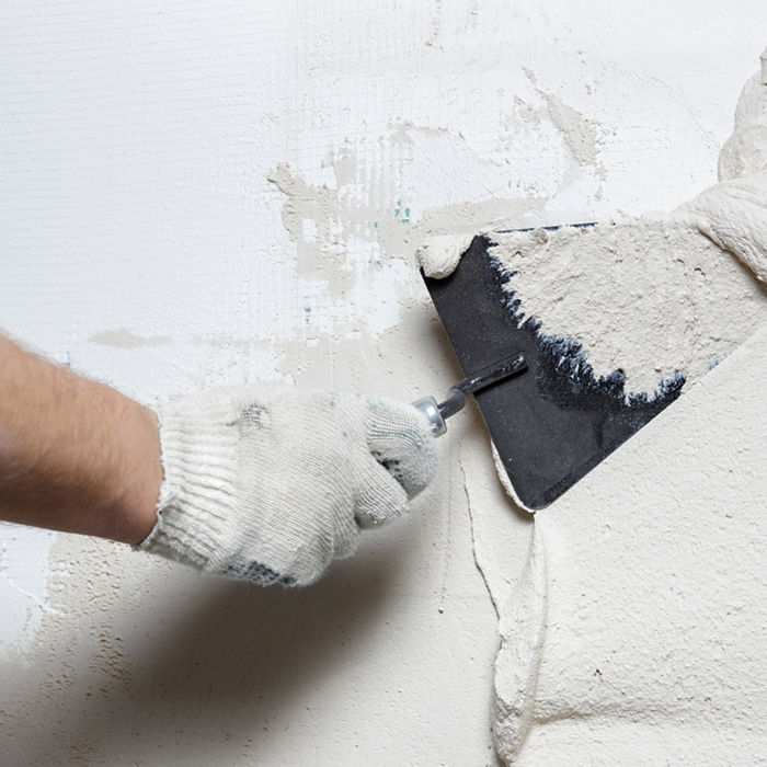 Construction worker with trowel plastering a wall; Shutterstock ID 600208748