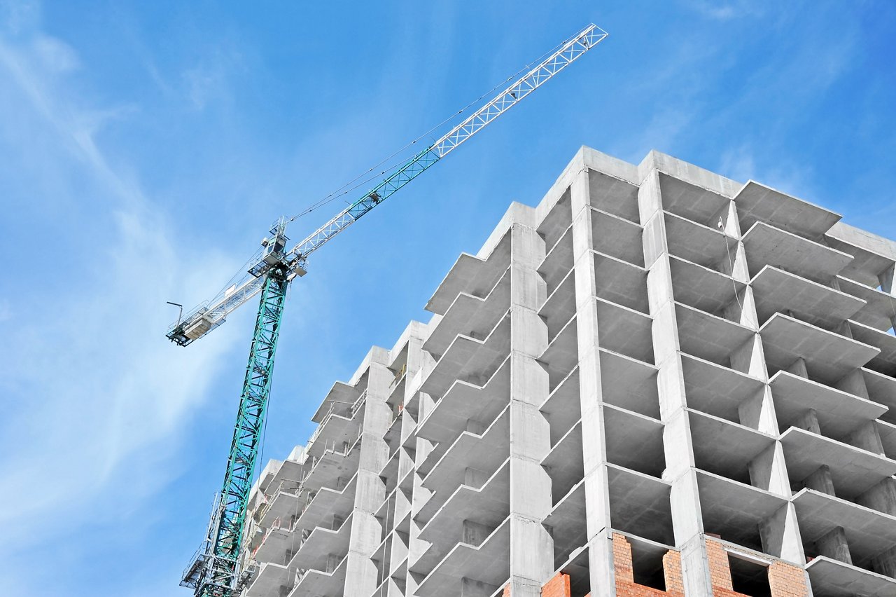 Crane and building construction site against blue sky; Shutterstock ID 269334134
