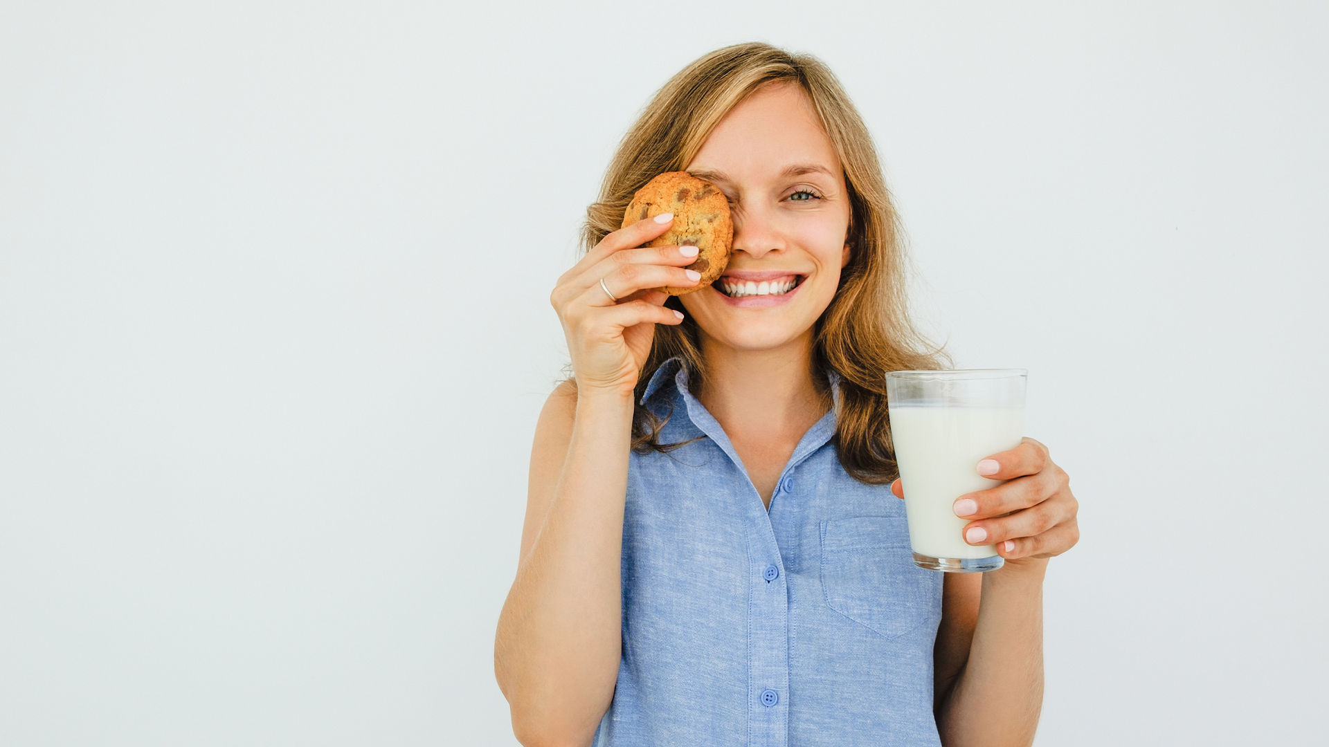 Woman Holding Glass of Milk and Cookie; Shutterstock ID 689900761