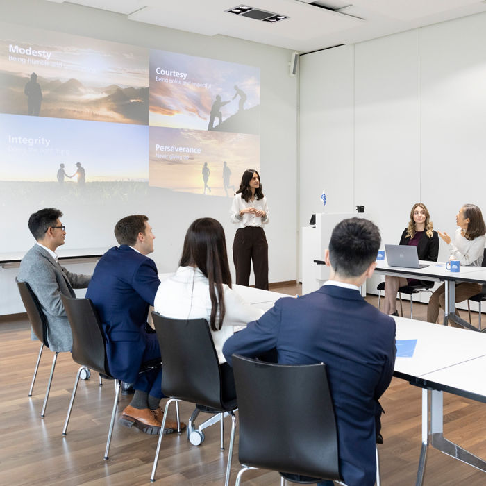 Group of people in a conference room listening to the speaker