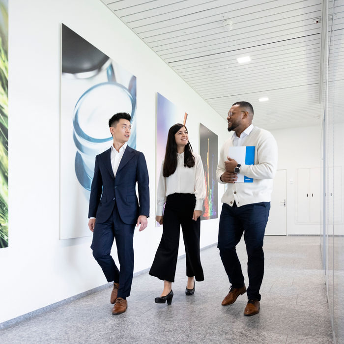 Three coworkers walking down a hallway 