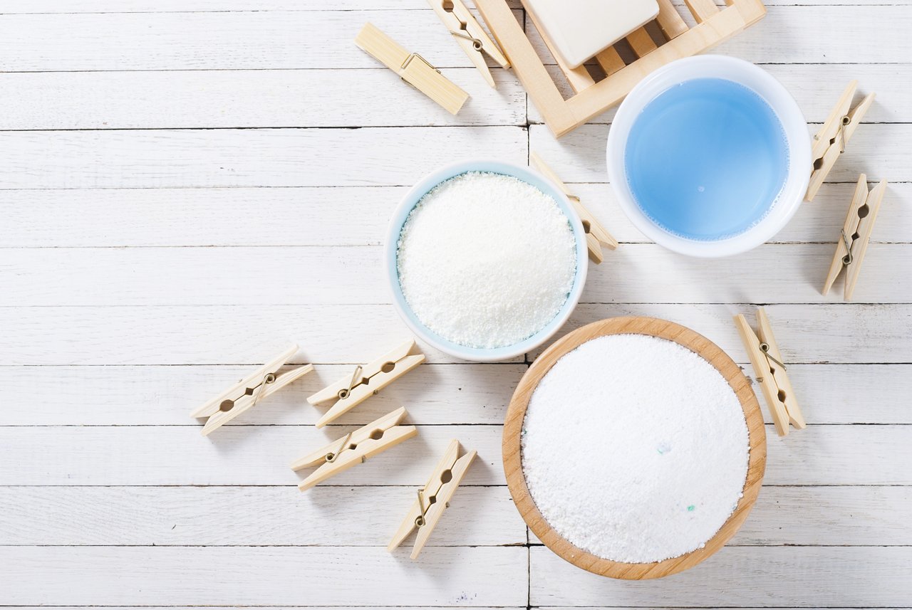 different washing powders, liquid and soap with clothes pins on white wood ; Shutterstock ID 500072440