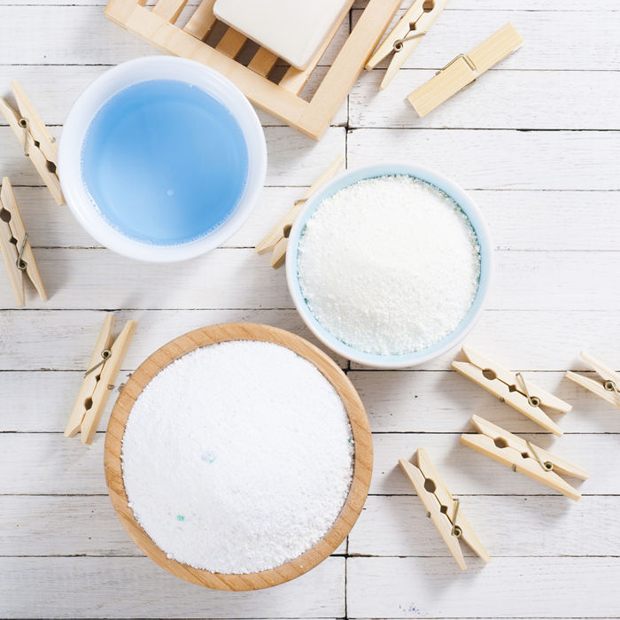different washing powders, liquid and soap with clothes pins on white wood ; Shutterstock ID 500072440