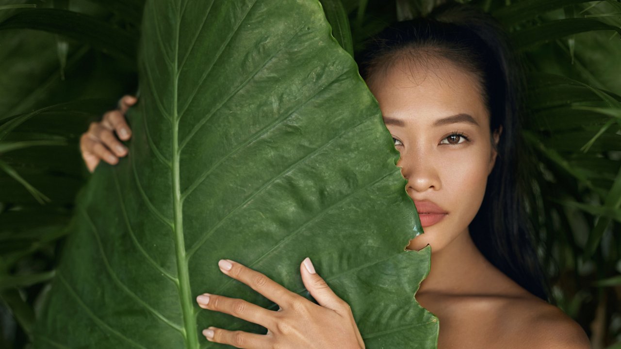 woman behind green leave