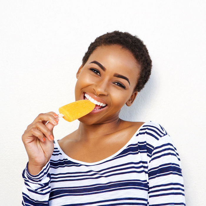Portrait of young woman eating ice cream; Shutterstock ID 576995239