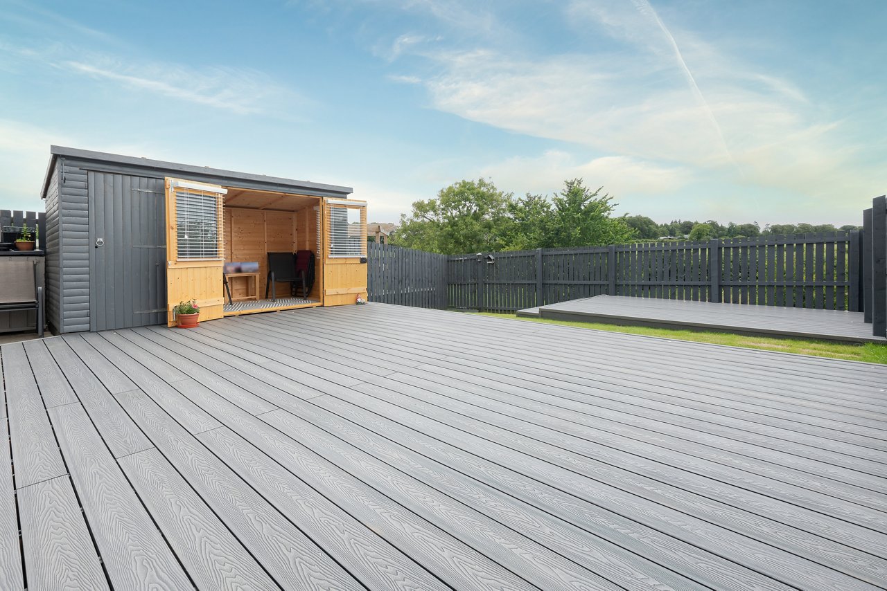 Ash grey composite decking built on two levels on a residential back garden with low voltage deck lights installed as well. Good Image for a landscape Gardiner; Shutterstock ID 2182483905; purchase_order: -; job: -; client: -; other: -
