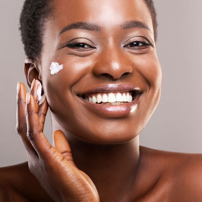 Woman applying cream on her face