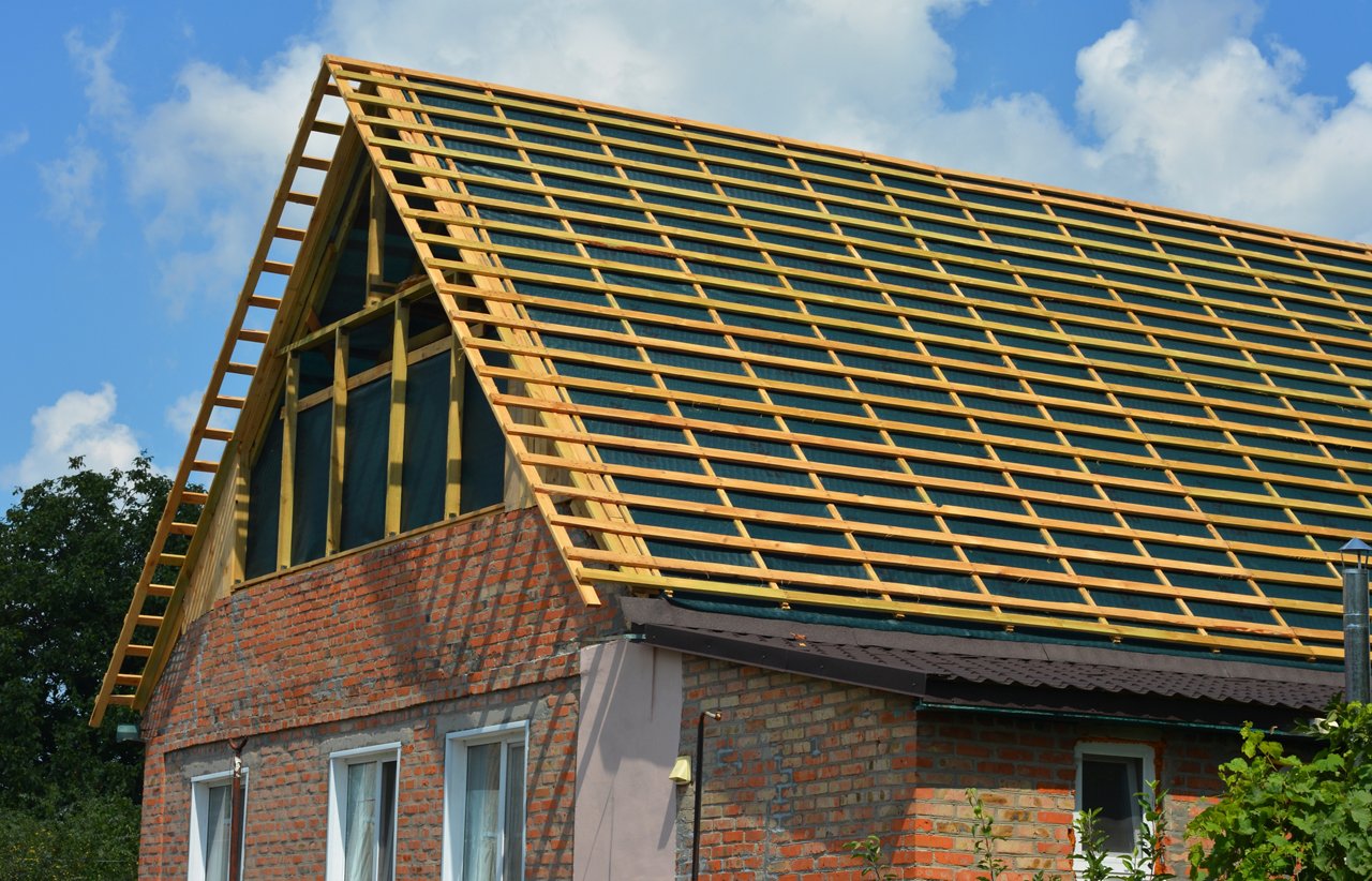 Roofing construction and renovation. Installing a new roof underlay and timber battens on a gable roof with a large roof window before tiles installation.; Shutterstock ID 2135861947; purchase_order: POL Breathable Films; job: ; client: POL Breathable Films; other: 