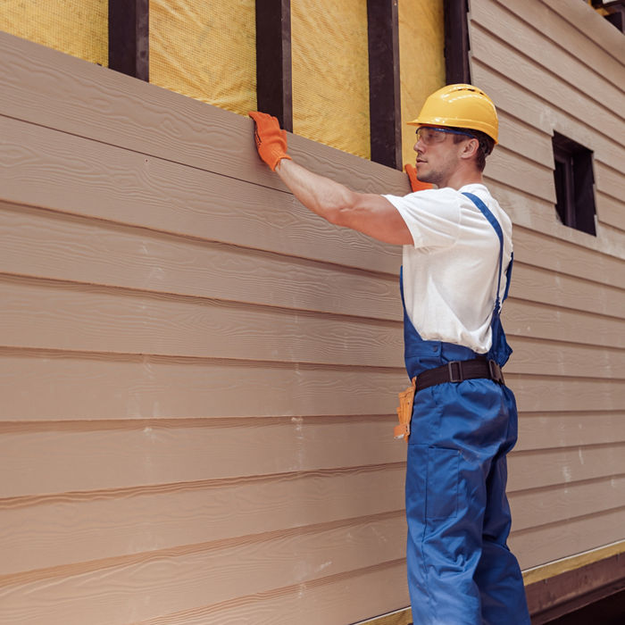 Male worker building house at construction site