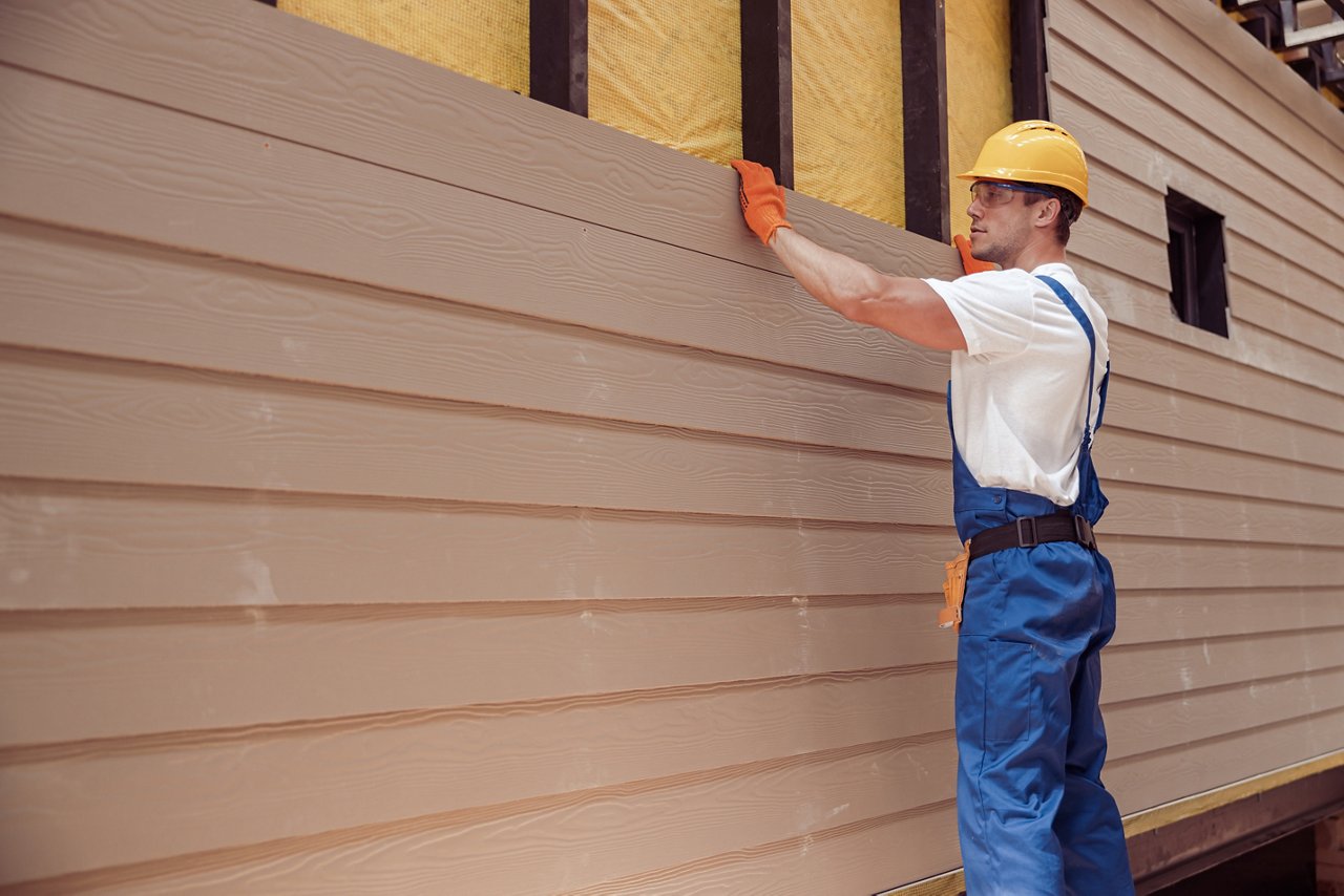 Male worker building house at construction site