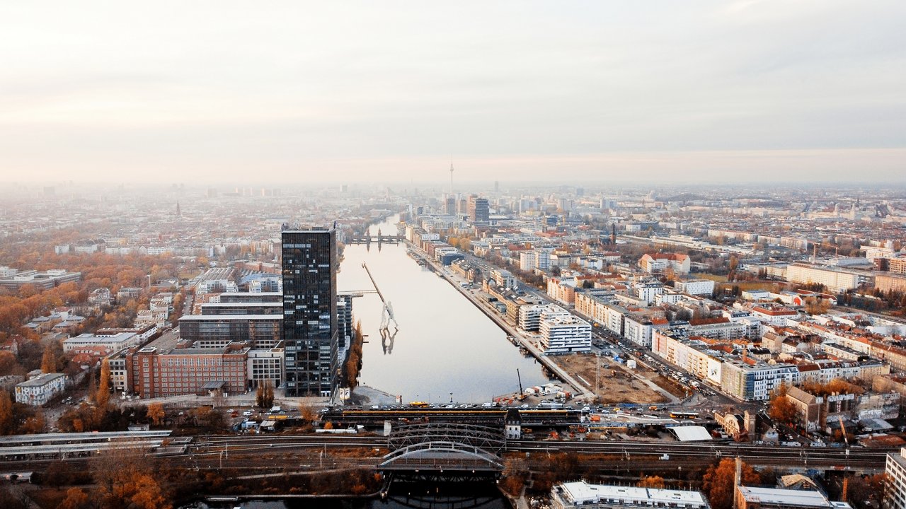 Aerial drone view of Berlin, Germany. District with river, yellowed trees, buildings and Berlin Television Tower in the distance