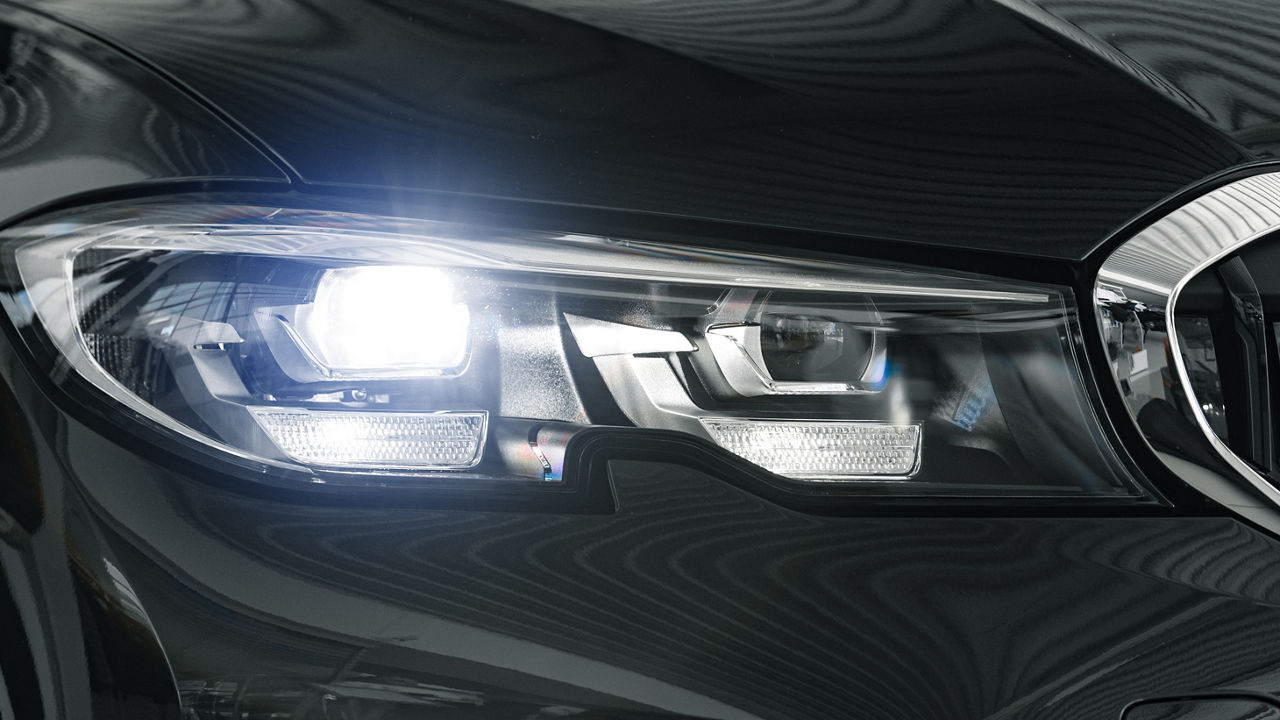 Headlights of a new white luxury car close up