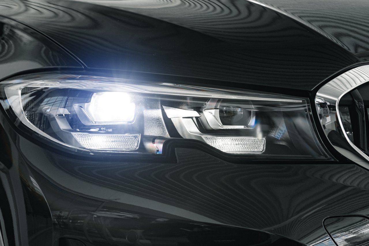 Headlights of a new white luxury car close up