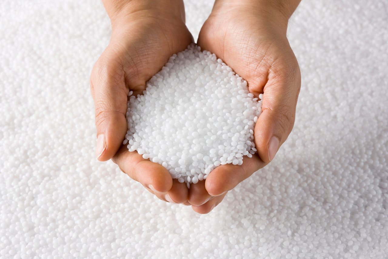 Plastic White Round Resin Pellets in a Holding Hand