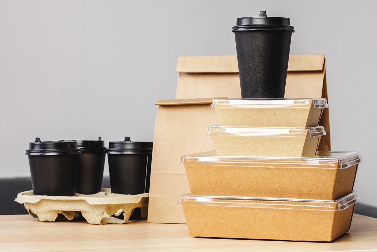 Many various take-out food containers, pizza box, coffee cups and paper bags on light grey background. Food delivery