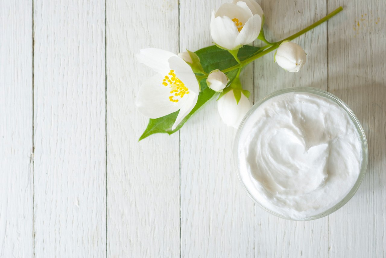 face cream with jasmine blossom on white wooden table; Shutterstock ID 144564611
