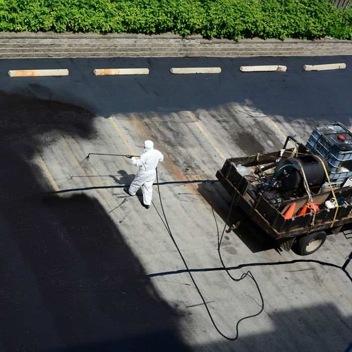 person sealing a parking lot