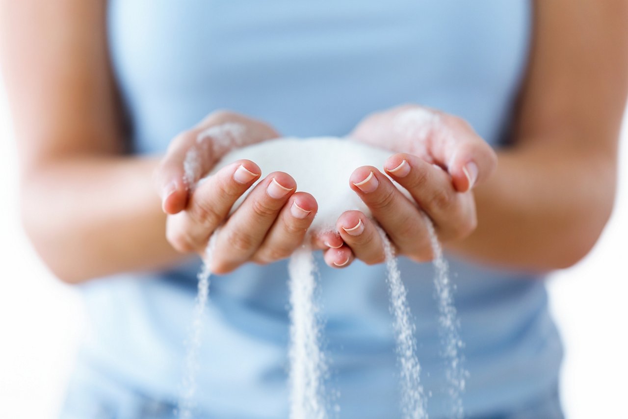 Close-up of white sugar in the woman hands. Heap of white sugar.; Shutterstock ID 1217732431; purchase_order: POL_Website_Recycled CaCO_Omyaloop FC; job: ; client: ; other: 
