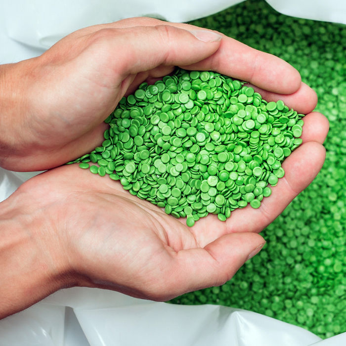 A hands hold or touching biodegradable plastic pellets, plastic polymer dye granules color clear green; Shutterstock ID 1335481439; purchase_order: POL Website_GDS EM page; job: ; client: ; other: 