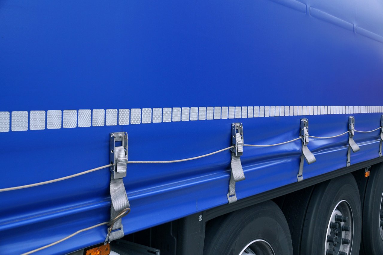 Truck transport. View of the tarpaulin covering the semi-trailer of the truck. ; Shutterstock ID 1464572615; purchase_order: POL_website_Automotive; job: ; client: ; other: 