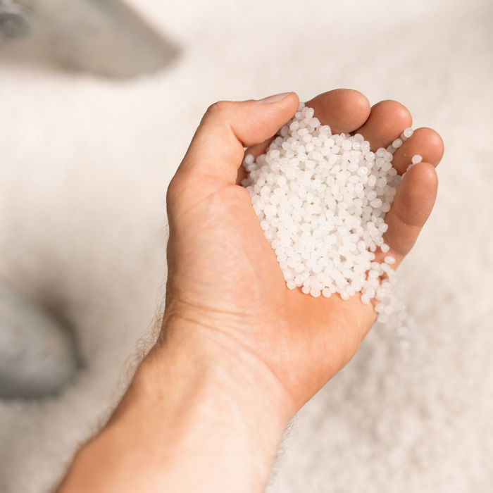 Hand of young male worker of large modern factory holding polymer granules; Shutterstock ID 1470308972; purchase_order: POL Website_masterbatch and compounds; job: ; client: ; other: 