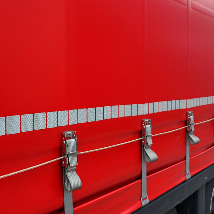 View of the red tarpaulin covering the semi-trailer of the truck