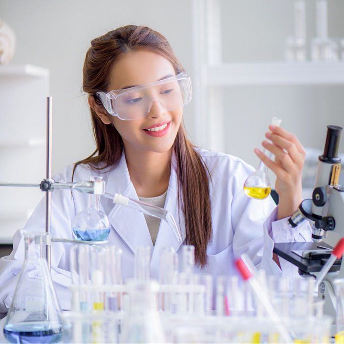 Female scientist working with laboratory collectors, holding a flask and test tubes