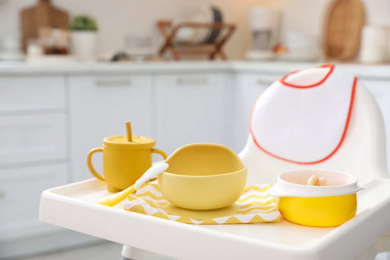 High chair with set of baby tableware on tray indoors; Shutterstock ID 2124976238; purchase_order: OPP Website & Media; job: ; client: ; other: 