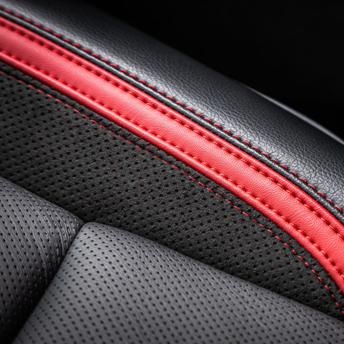 close-up black and red  perforated leather car seat. Skin texture; Shutterstock ID 2300504413; purchase_order: POL Website Automotive_Plastisols; job: ; client: ; other: 