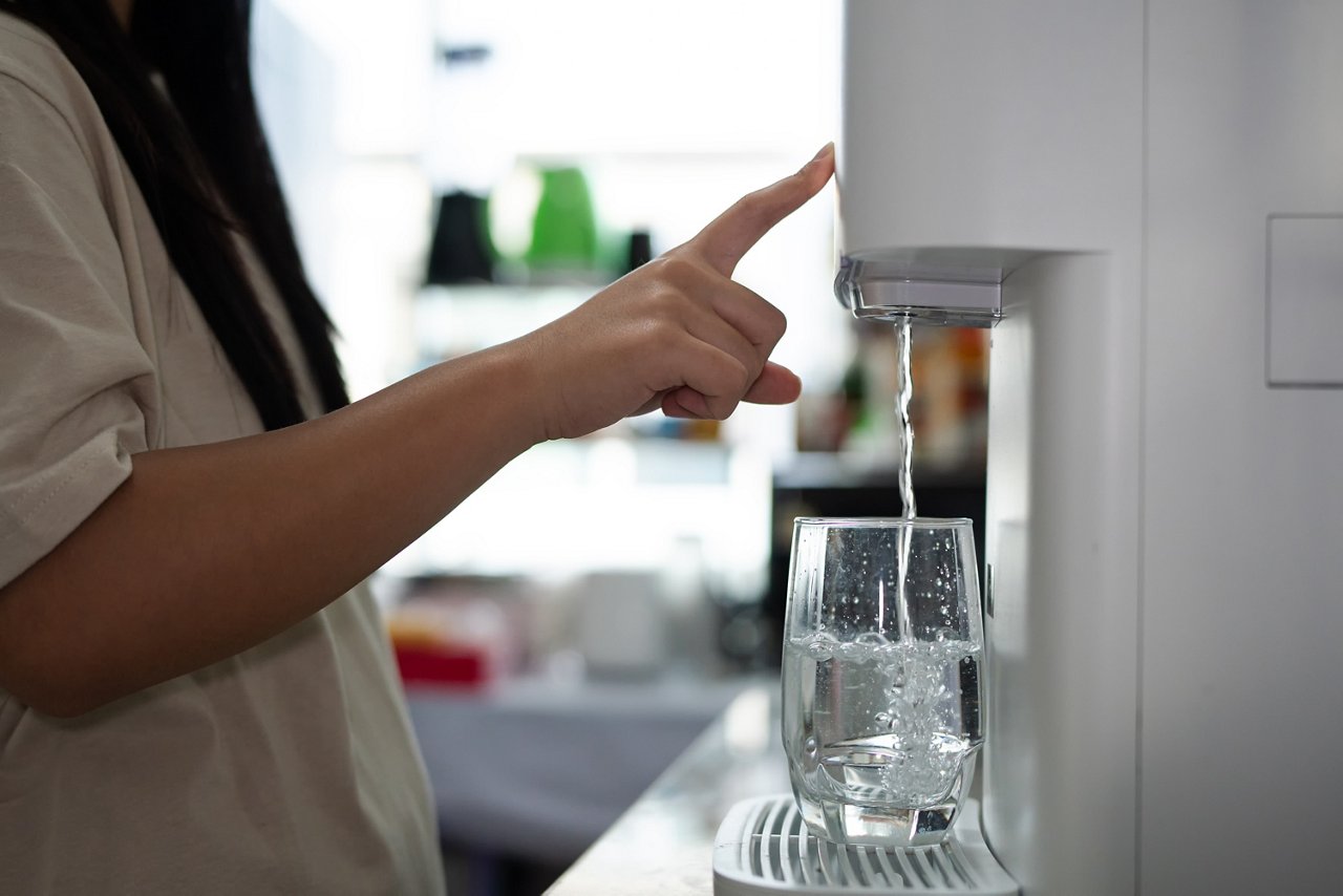 Home water purifier. Modern water dispenser filling a glass; hand pressing the button for fresh water,Close up shot of a person s hand filling a glass from water purifier.; Shutterstock ID 2755724541; purchase_order: OPP Media & Collateral; job: ; client: ; other: 
